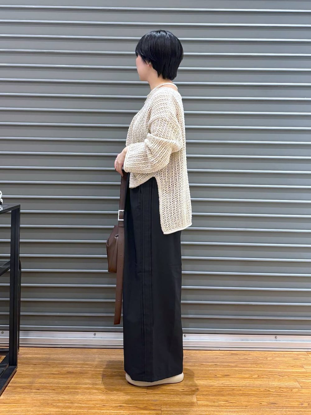 ブラック系のショルダーバッグ、ホワイト系のニット/セーター、ブラック系のその他パンツを着用したレディースの夏コーディネートの3枚目の写真