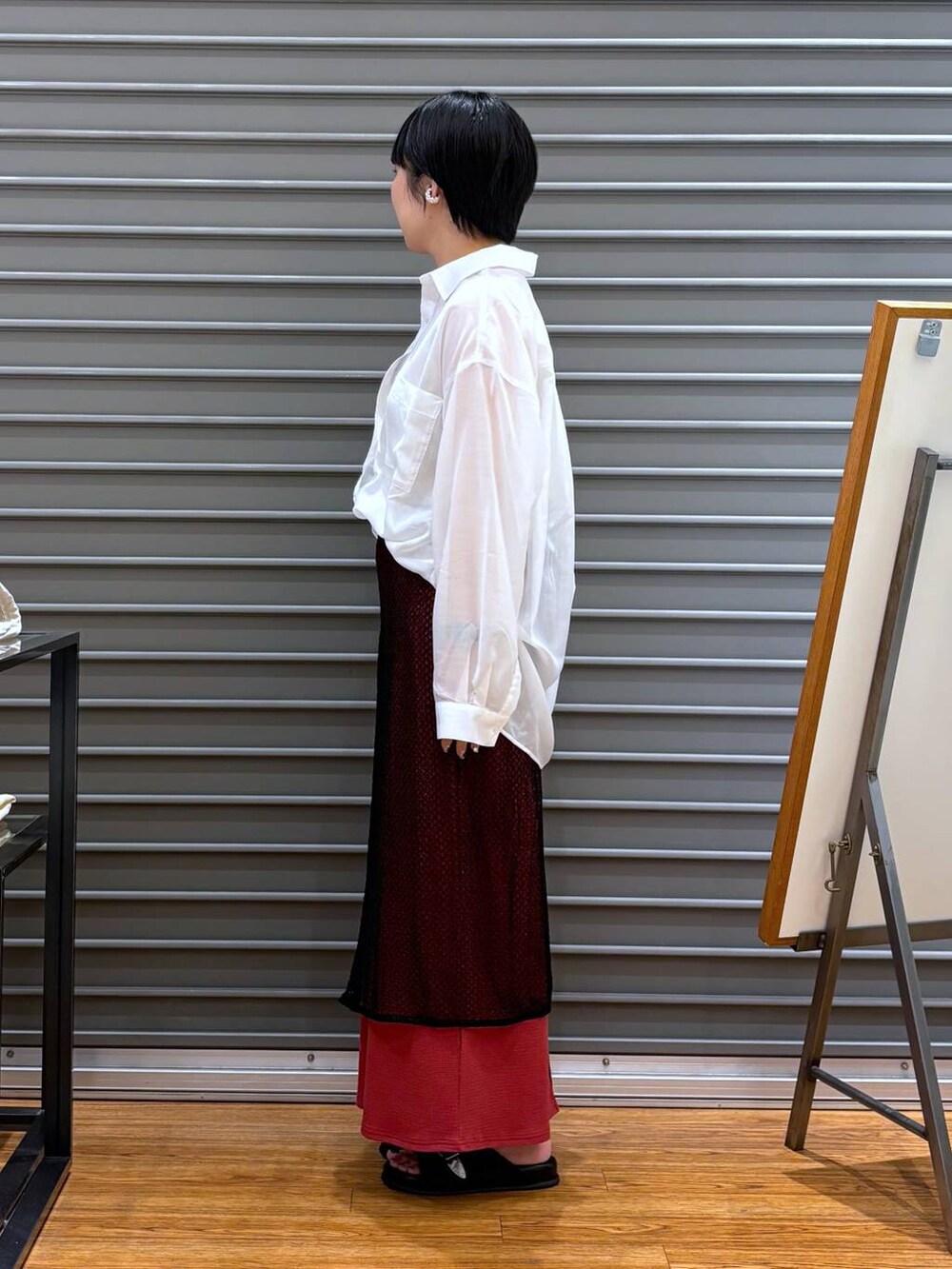 ホワイト系のタンクトップ、レッド系のスカート、ブラック系のサンダルを着用したレディースの夏コーディネートの3枚目の写真