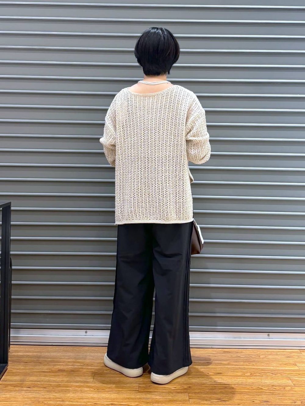 ブラック系のショルダーバッグ、ホワイト系のニット/セーター、ブラック系のその他パンツを着用したレディースの夏コーディネートの4枚目の写真