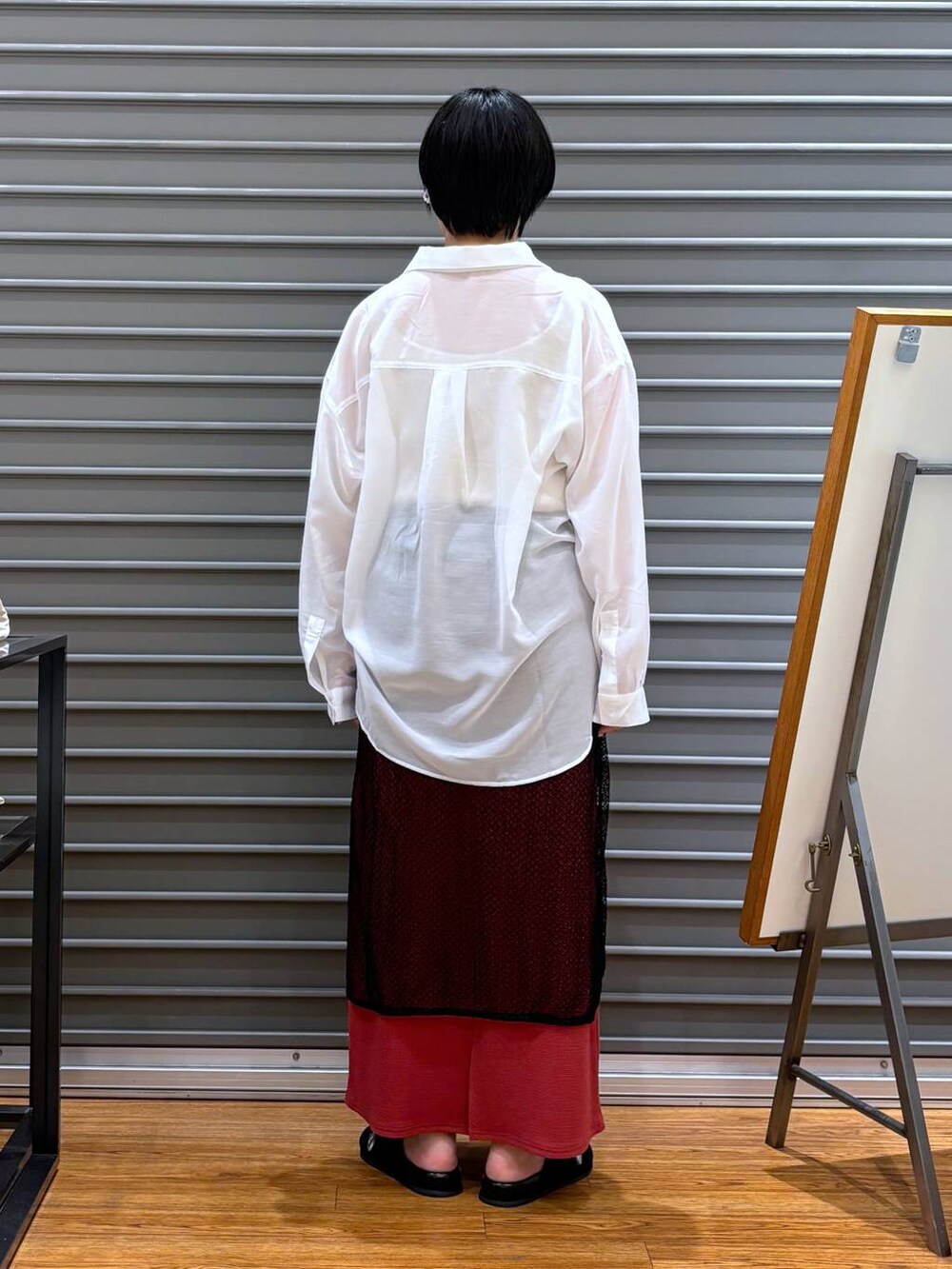 ホワイト系のタンクトップ、レッド系のスカート、ブラック系のサンダルを着用したレディースの夏コーディネートの4枚目の写真