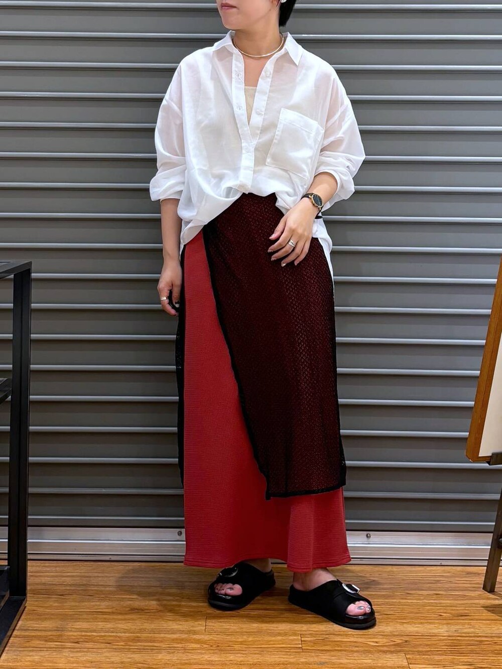 ホワイト系のタンクトップ、レッド系のスカート、ブラック系のサンダルを着用したレディースの夏コーディネートの2枚目の写真