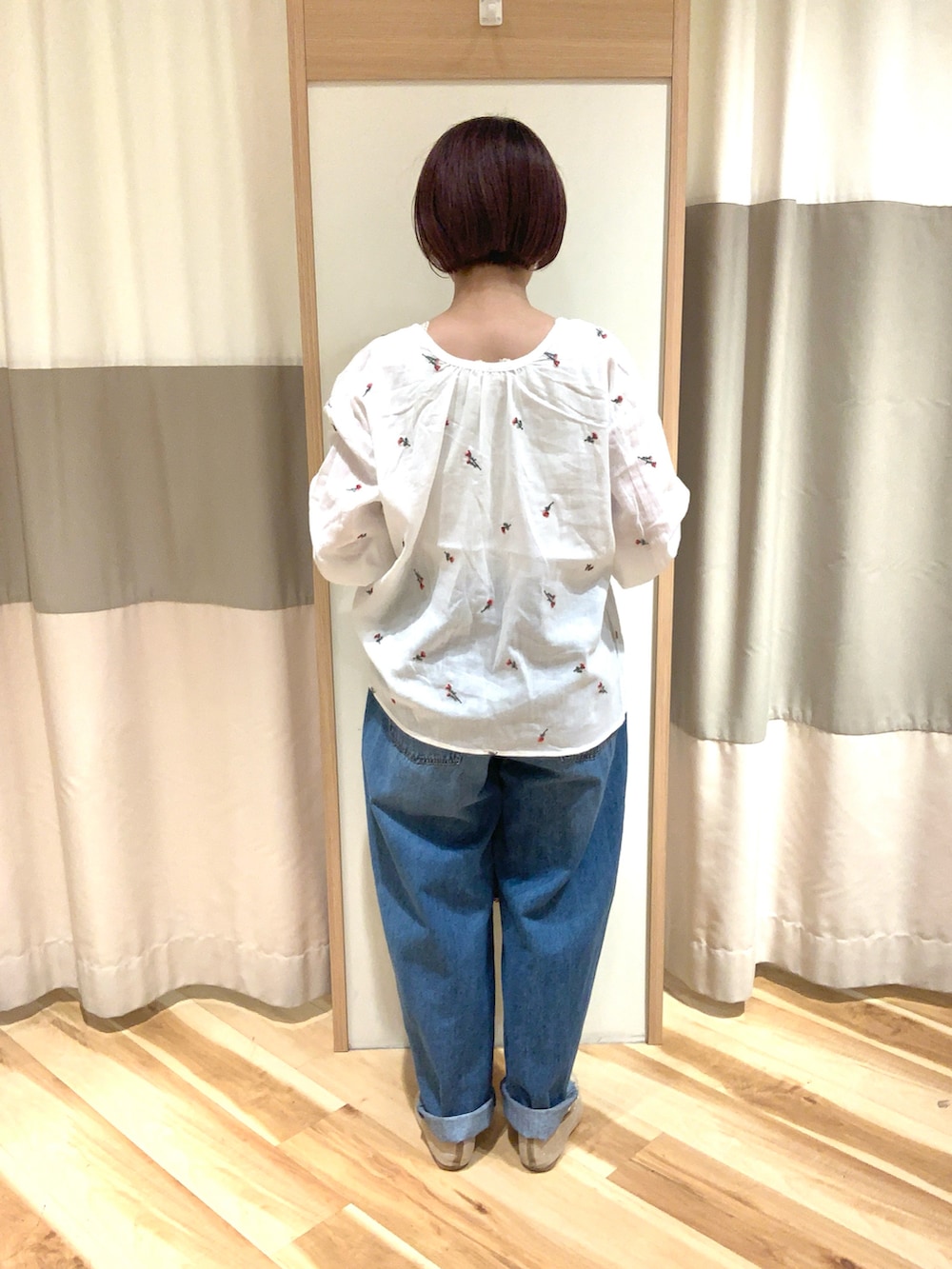 ホワイト系のシャツ/ブラウス、ブルー系のデニムパンツ、ベージュ系のハンドバッグを着用したレディースの夏コーディネートの3枚目の写真