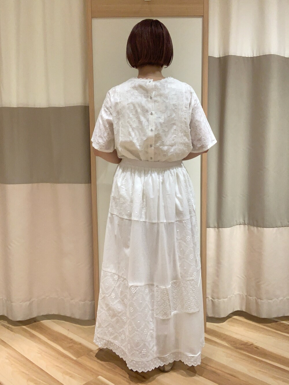 ホワイト系のシャツ/ブラウス、ホワイト系のスカート、ベージュ系のハンドバッグを着用したレディースの春コーディネートの5枚目の写真
