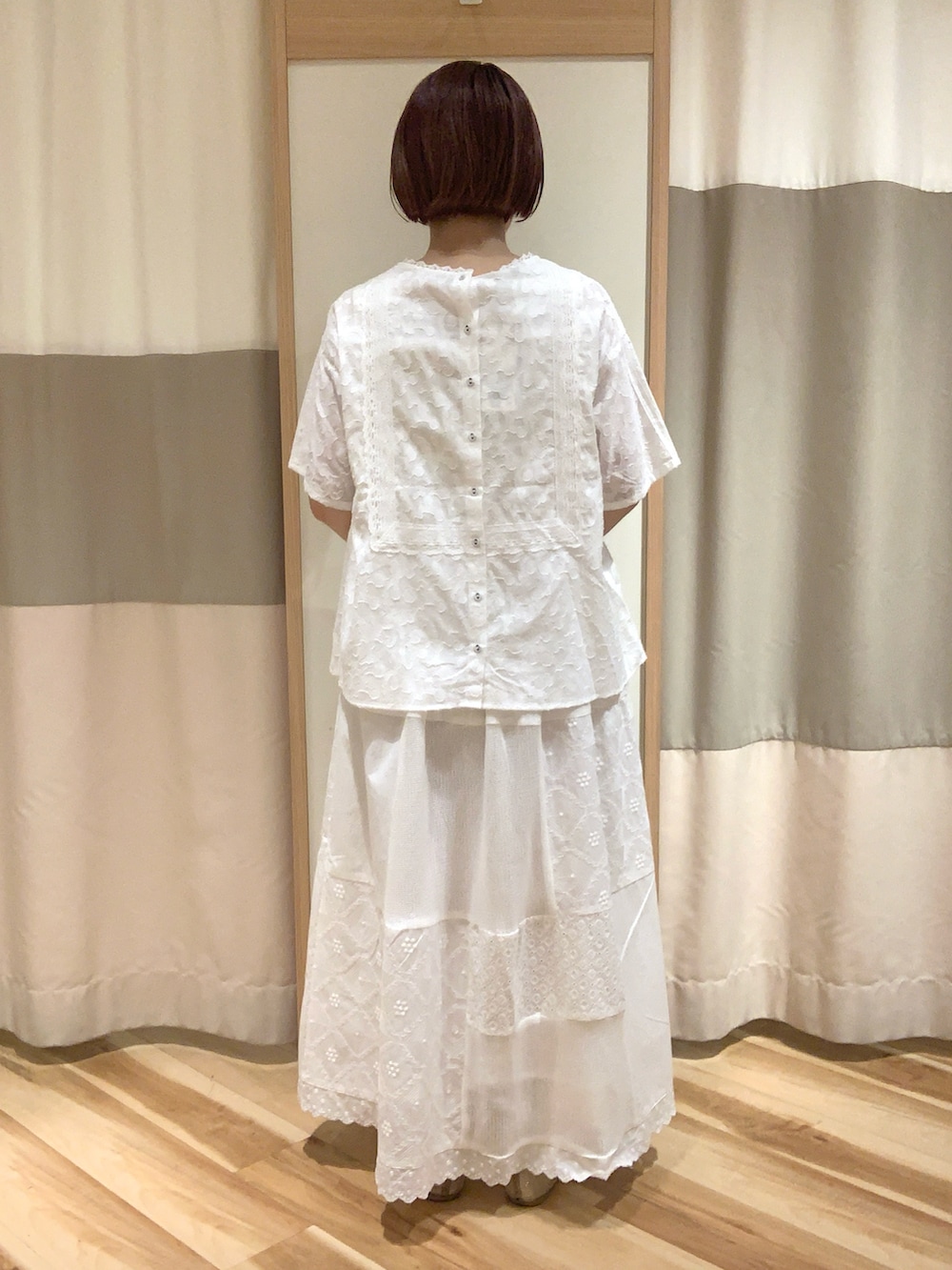 ホワイト系のシャツ/ブラウス、ホワイト系のスカート、ベージュ系のハンドバッグを着用したレディースの春コーディネートの3枚目の写真