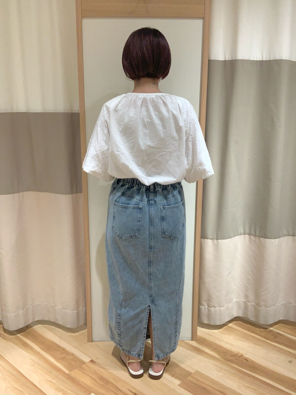 ベージュ系のハンドバッグ、ホワイト系のシャツ/ブラウス、ブルー系のスカートを着用したレディースの夏コーディネートの3枚目の写真