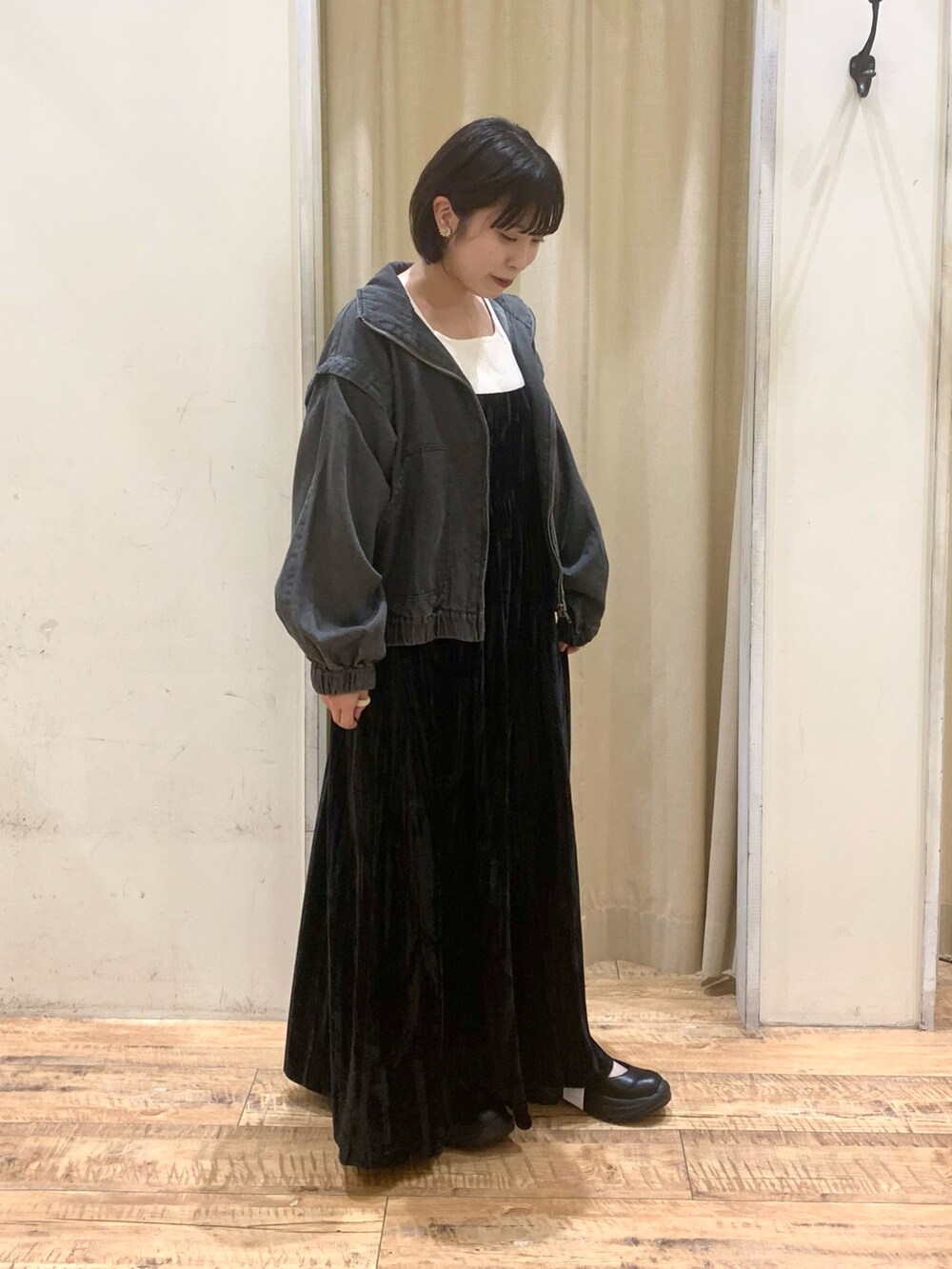 ブラック系のスニーカー、ブラック系のワンピース、グレー系のブルゾンを着用したレディースの秋コーディネートの2枚目の写真