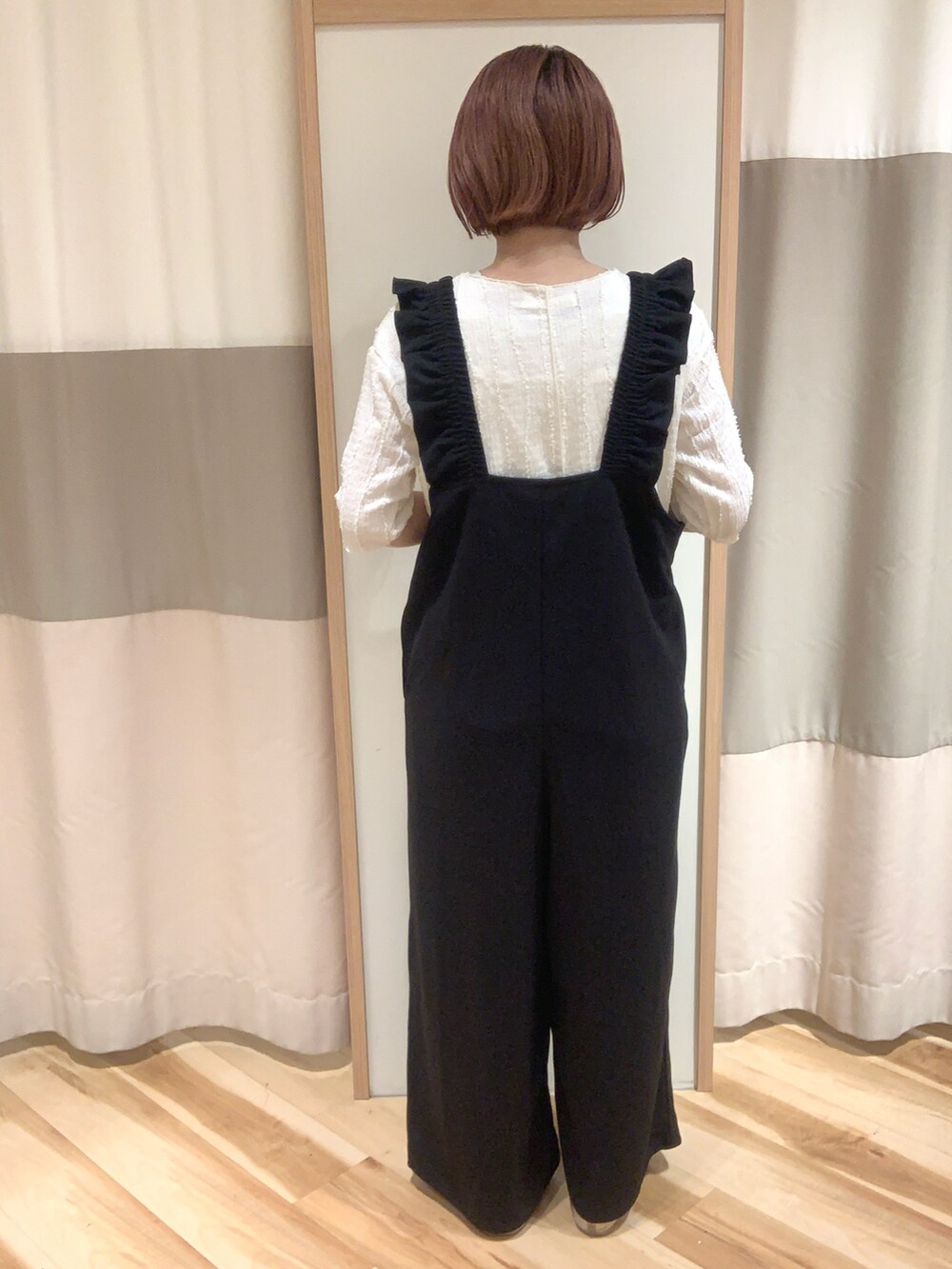 ブラック系のサロペット/オーバーオール、ホワイト系のTシャツ/カットソー、ホワイト系のハンドバッグを着用したレディースの春コーディネートの3枚目の写真