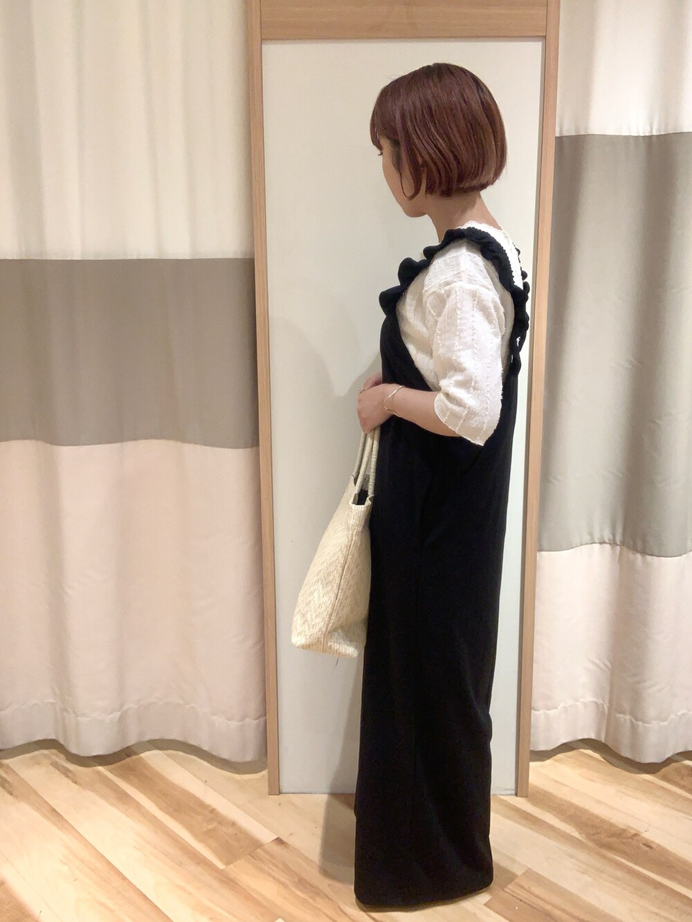 ブラック系のサロペット/オーバーオール、ホワイト系のTシャツ/カットソー、ホワイト系のハンドバッグを着用したレディースの春コーディネートの2枚目の写真