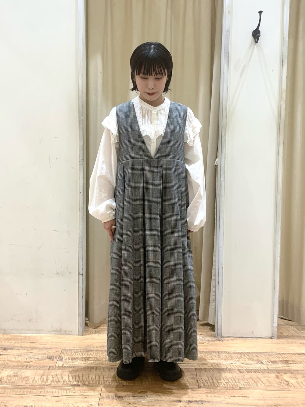 グレー系のワンピース、ホワイト系のシャツ/ブラウス、ブラック系のブーツを着用したレディースの秋コーディネートの3枚目の写真