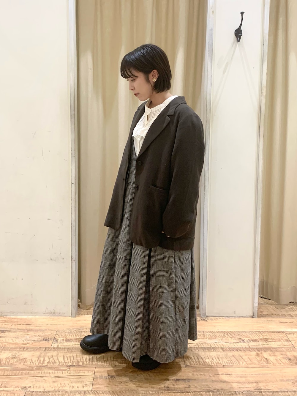 グレー系のワンピース、ホワイト系のシャツ/ブラウス、ブラック系のブーツを着用したレディースの秋コーディネートの2枚目の写真