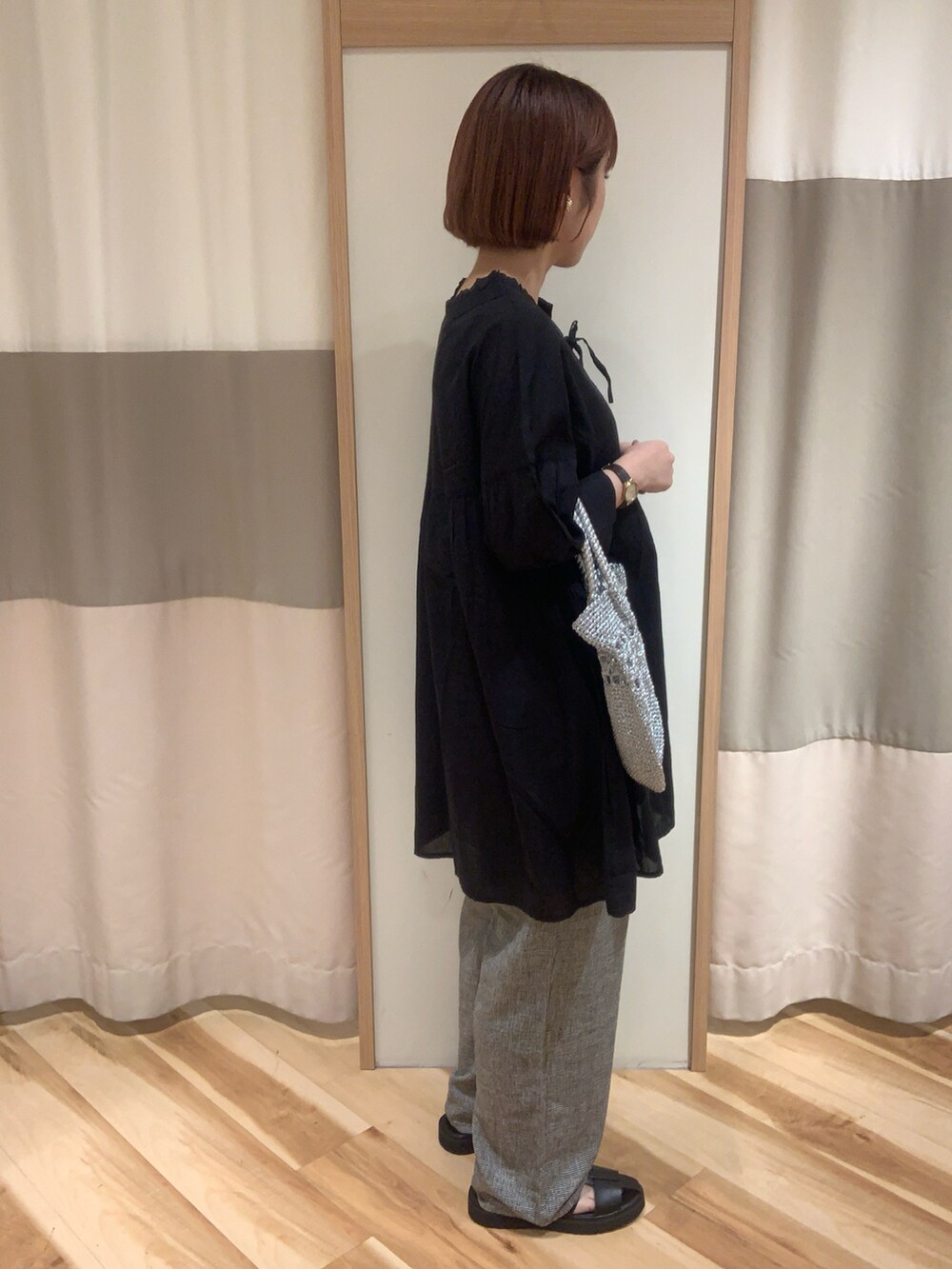 ブラック系のシャツ/ブラウス、シルバー系のハンドバッグ、ブラック系のパンツを着用したレディースの春コーディネートの2枚目の写真