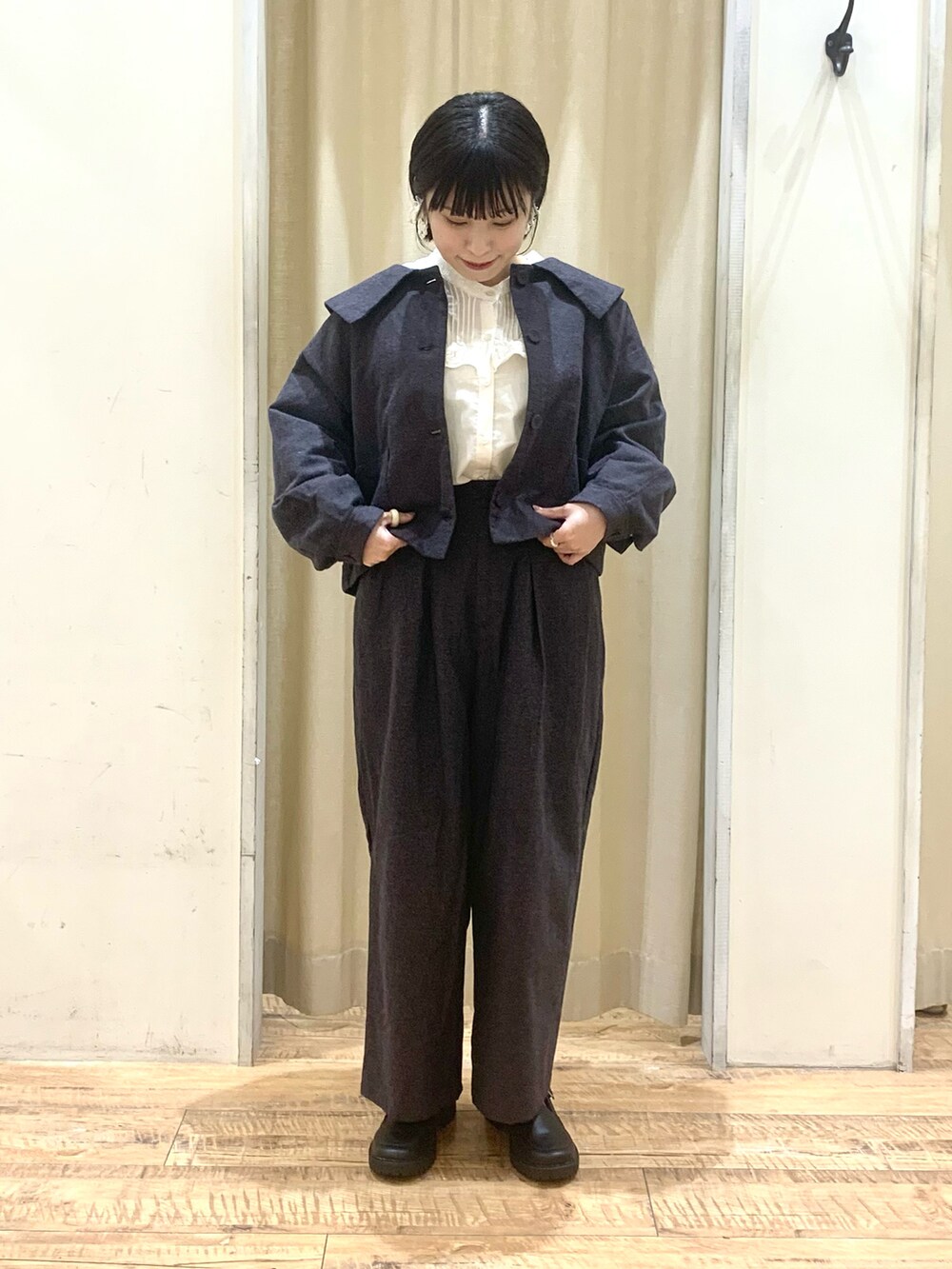 グレー系のハンドバッグ、ブラック系のパンツ、ブラック系のドレスシューズを着用したレディースの秋コーディネートの4枚目の写真