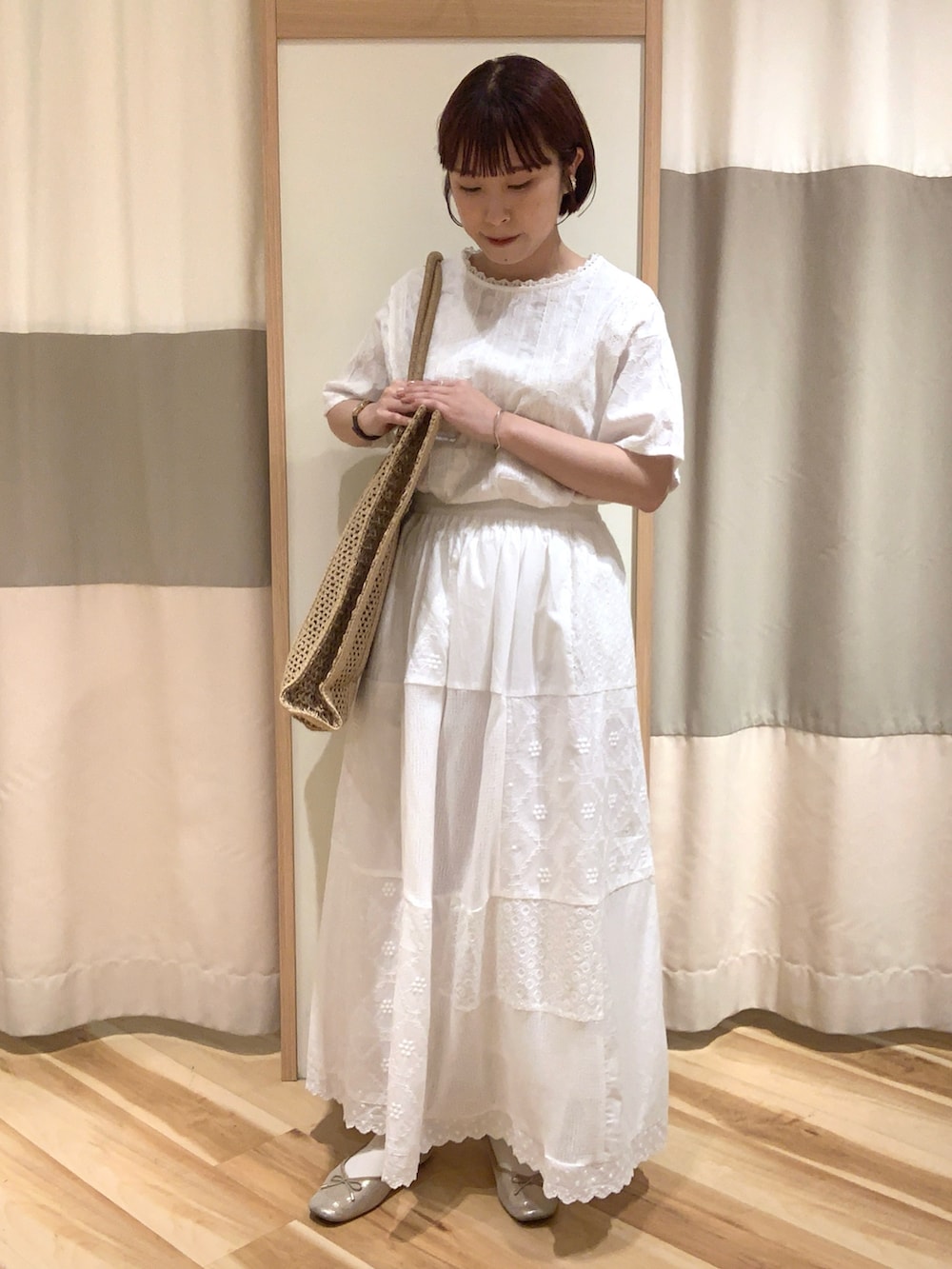 ホワイト系のシャツ/ブラウス、ホワイト系のスカート、ベージュ系のハンドバッグを着用したレディースの春コーディネートの4枚目の写真