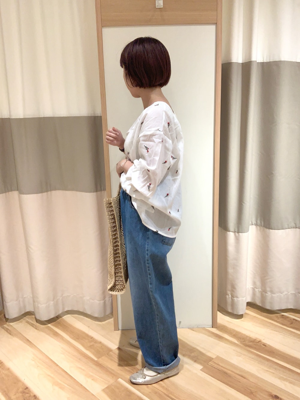 ホワイト系のシャツ/ブラウス、ブルー系のデニムパンツ、ベージュ系のハンドバッグを着用したレディースの夏コーディネートの2枚目の写真