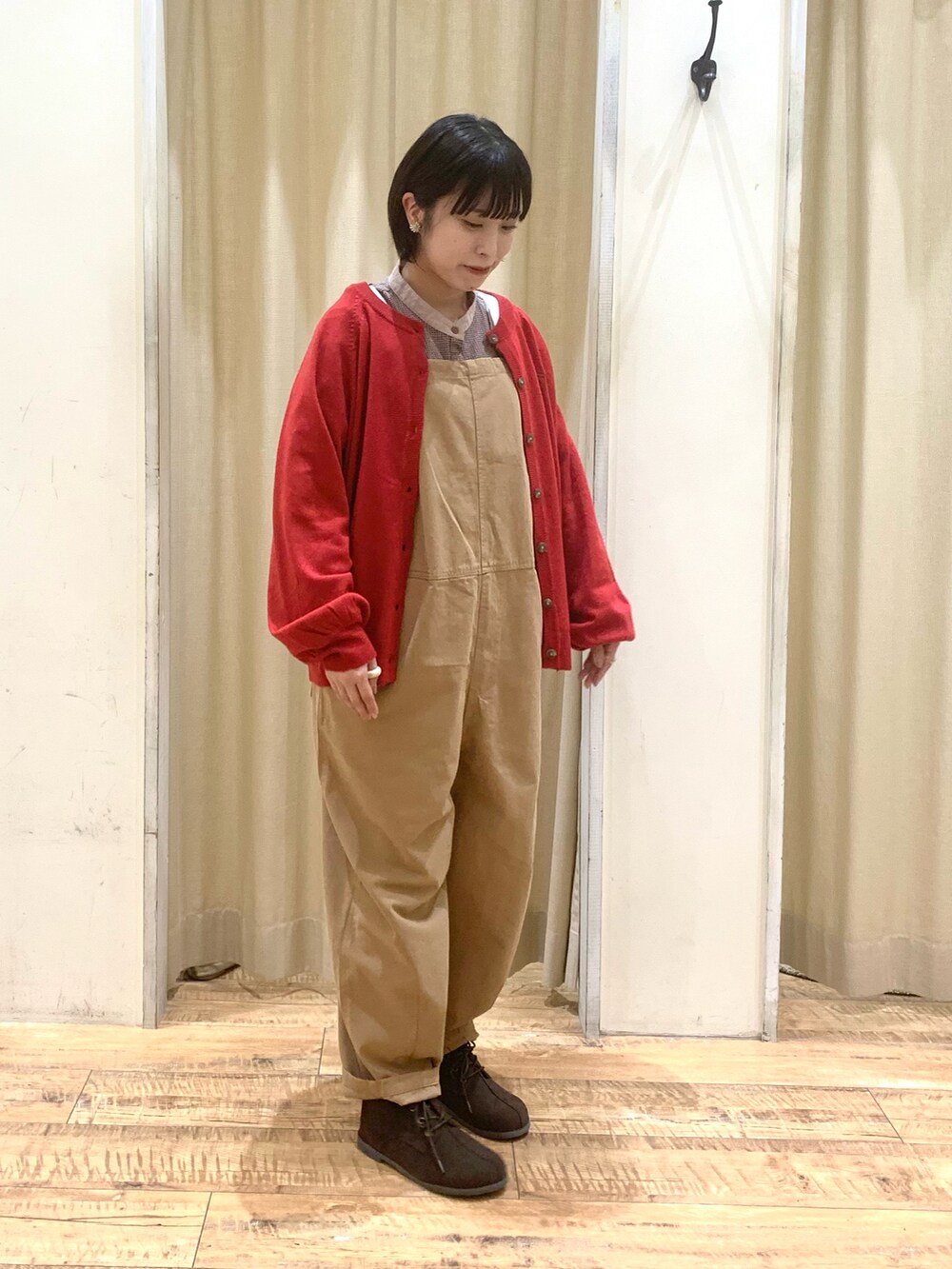 ベージュ系のサロペット/オーバーオール、レッド系のカーディガン/ボレロ、ブラウン系のシャツ/ブラウスを着用したレディースの秋コーディネートの2枚目の写真