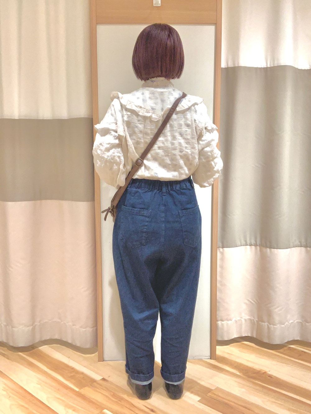 ホワイト系のシャツ/ブラウス、パープル系のTシャツ/カットソー、ブルー系のデニムパンツを着用したレディースの冬コーディネートの2枚目の写真