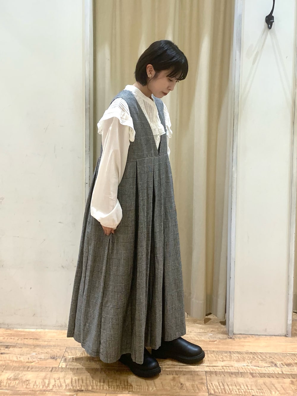 グレー系のワンピース、ホワイト系のシャツ/ブラウス、ブラック系のブーツを着用したレディースの秋コーディネートの4枚目の写真