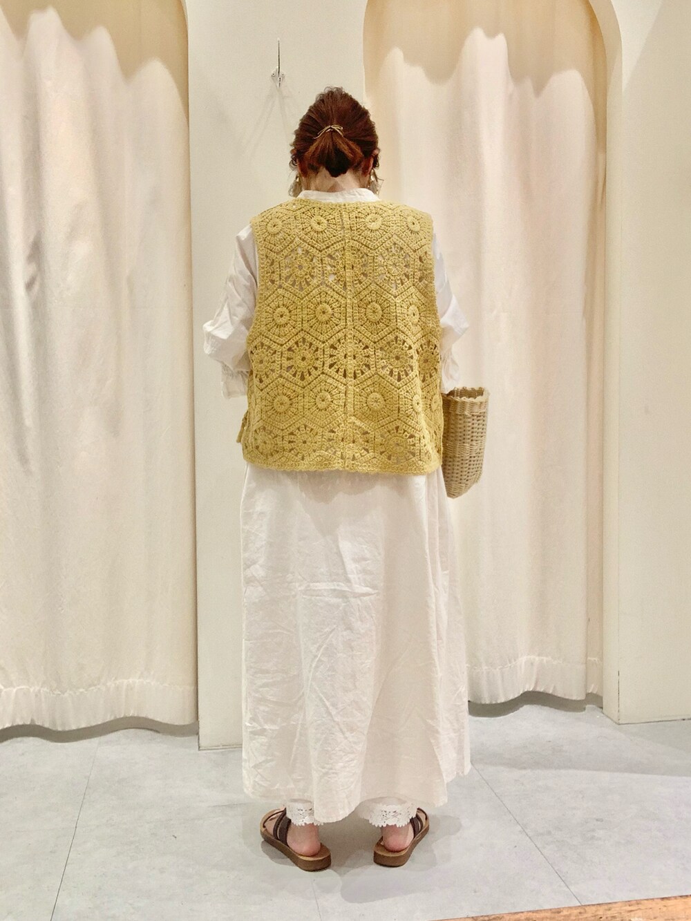 ブラウン系のサンダル、ベージュ系のトートバッグ、イエロー系のニット/セーターを着用したレディースの夏コーディネートの2枚目の写真