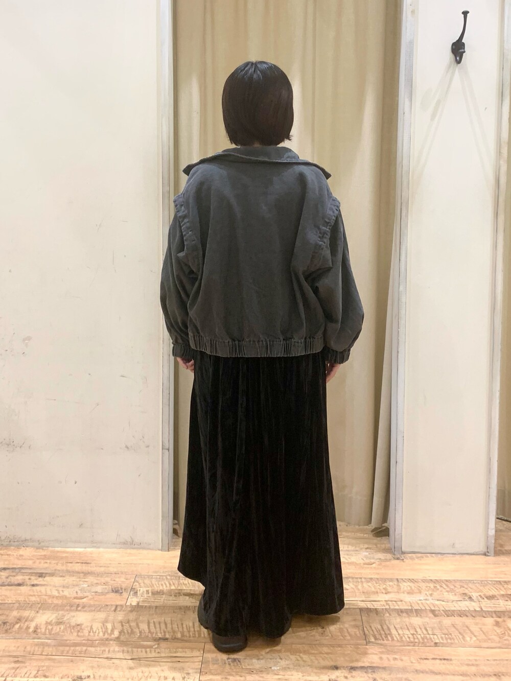 ブラック系のスニーカー、ブラック系のワンピース、グレー系のブルゾンを着用したレディースの秋コーディネートの3枚目の写真