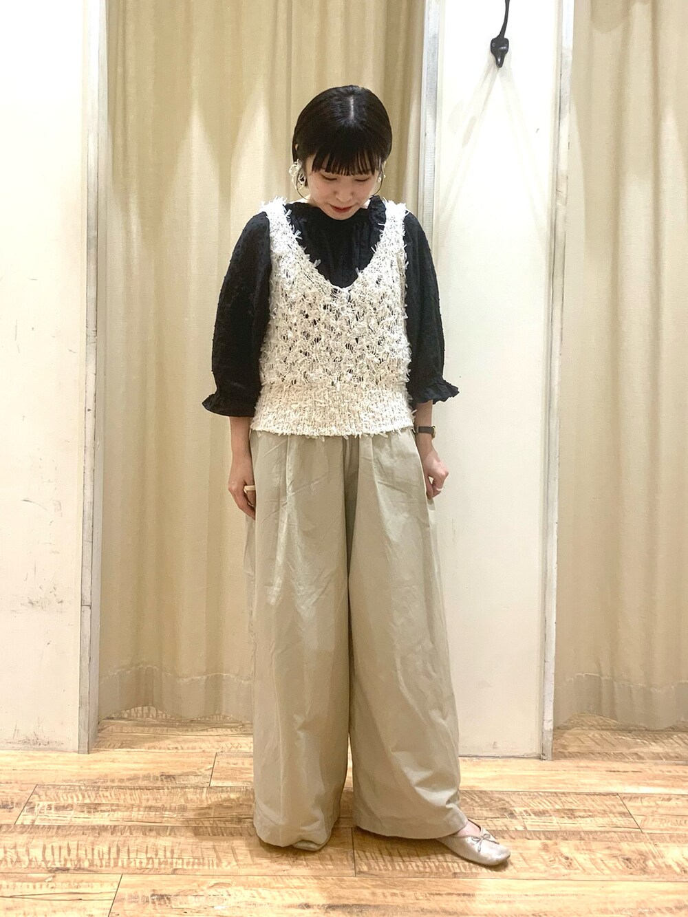 ホワイト系のベスト、ブラック系のシャツ/ブラウス、ベージュ系のパンツを着用したレディースの秋コーディネートの2枚目の写真