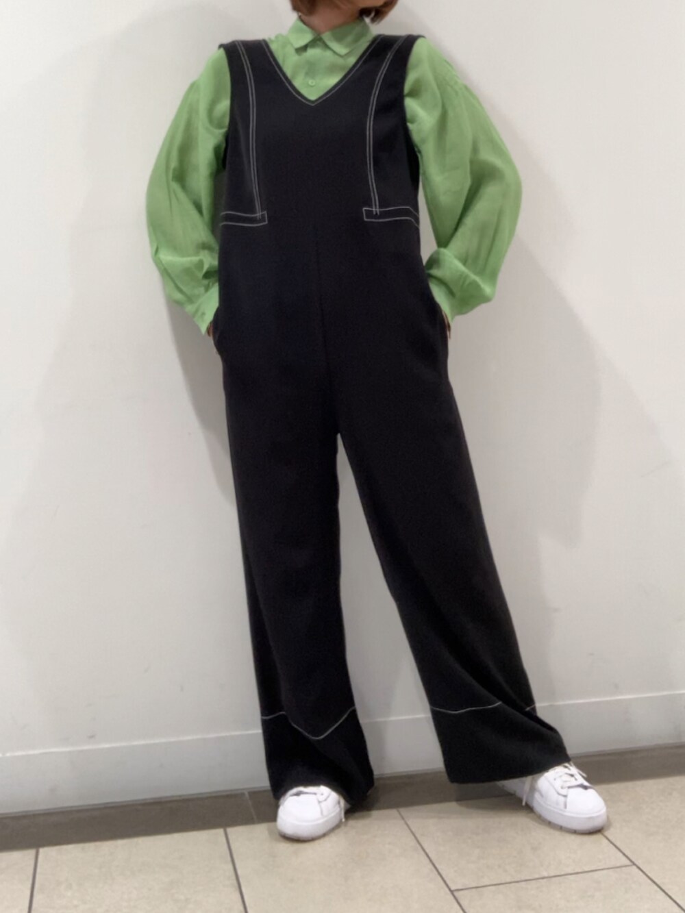 グリーン系のシャツ/ブラウス、ホワイト系のスニーカー、ブラック系のサロペット/オーバーオールを着用したレディースの春コーディネートの2枚目の写真