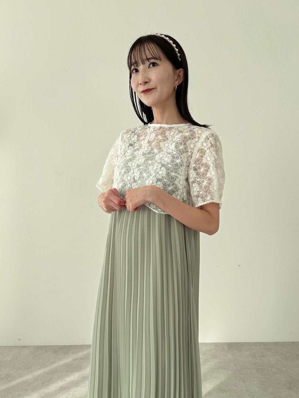 グリーン系のワンピース、ホワイト系のショルダーバッグを着用したレディースの冬コーディネートの3枚目の写真