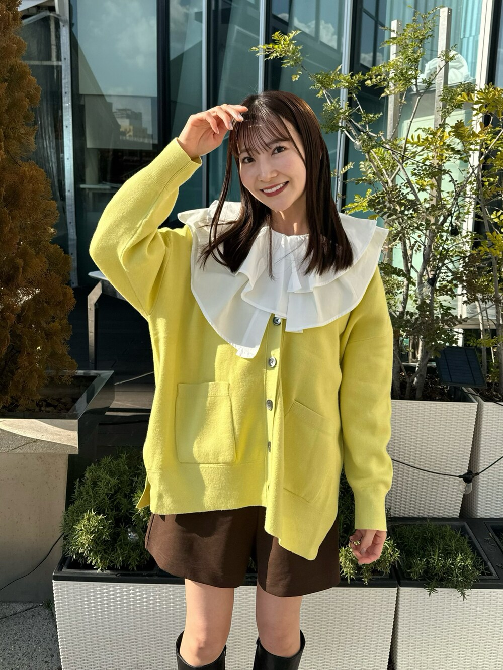 イエロー系のカーディガン/ボレロ、ホワイト系のチュニック、ブラウン系のその他パンツを着用したレディースの冬コーディネートの4枚目の写真