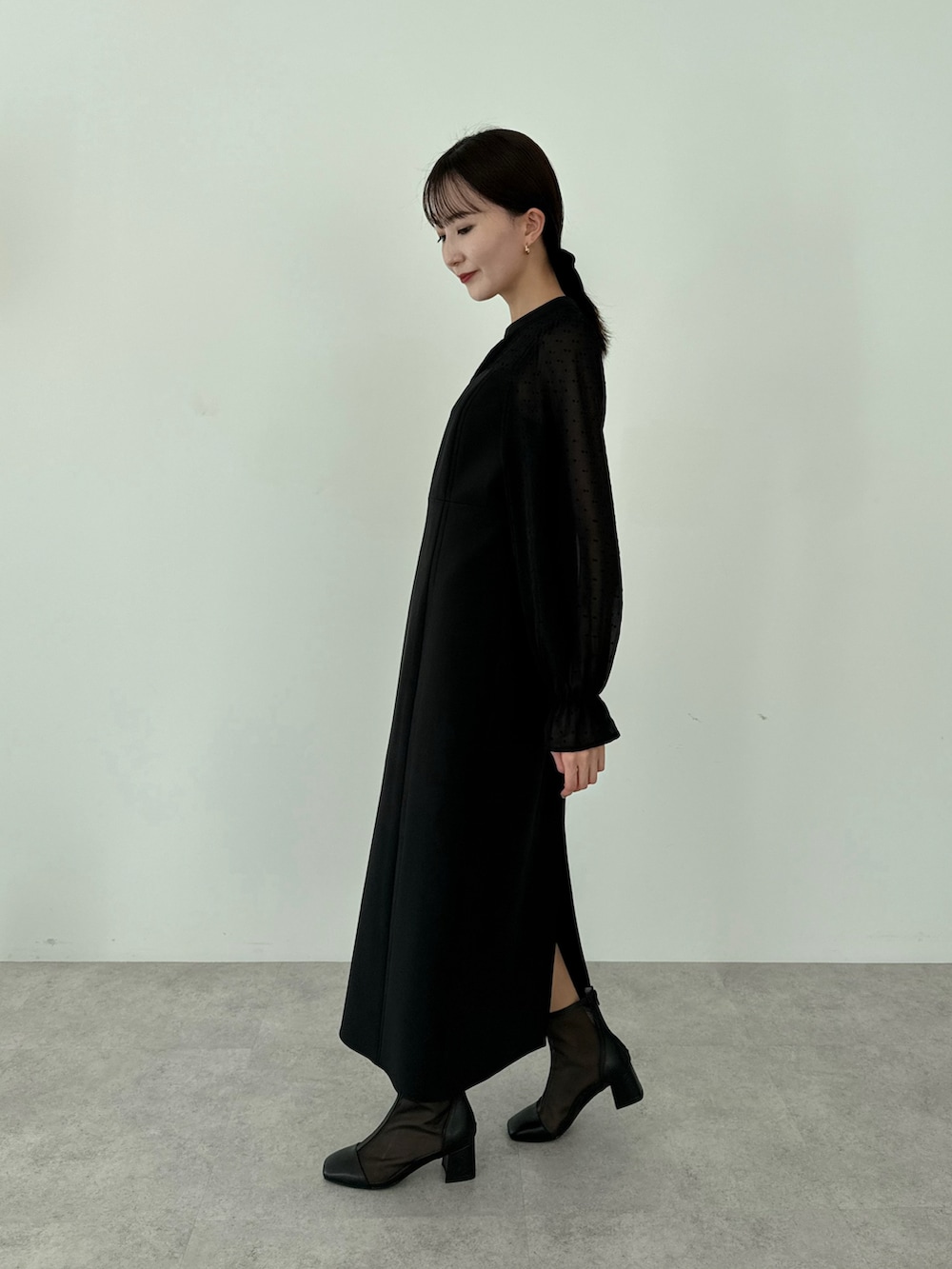 ブラック系のドレス、ブラック系のブーツを着用したレディースの春コーディネートの4枚目の写真