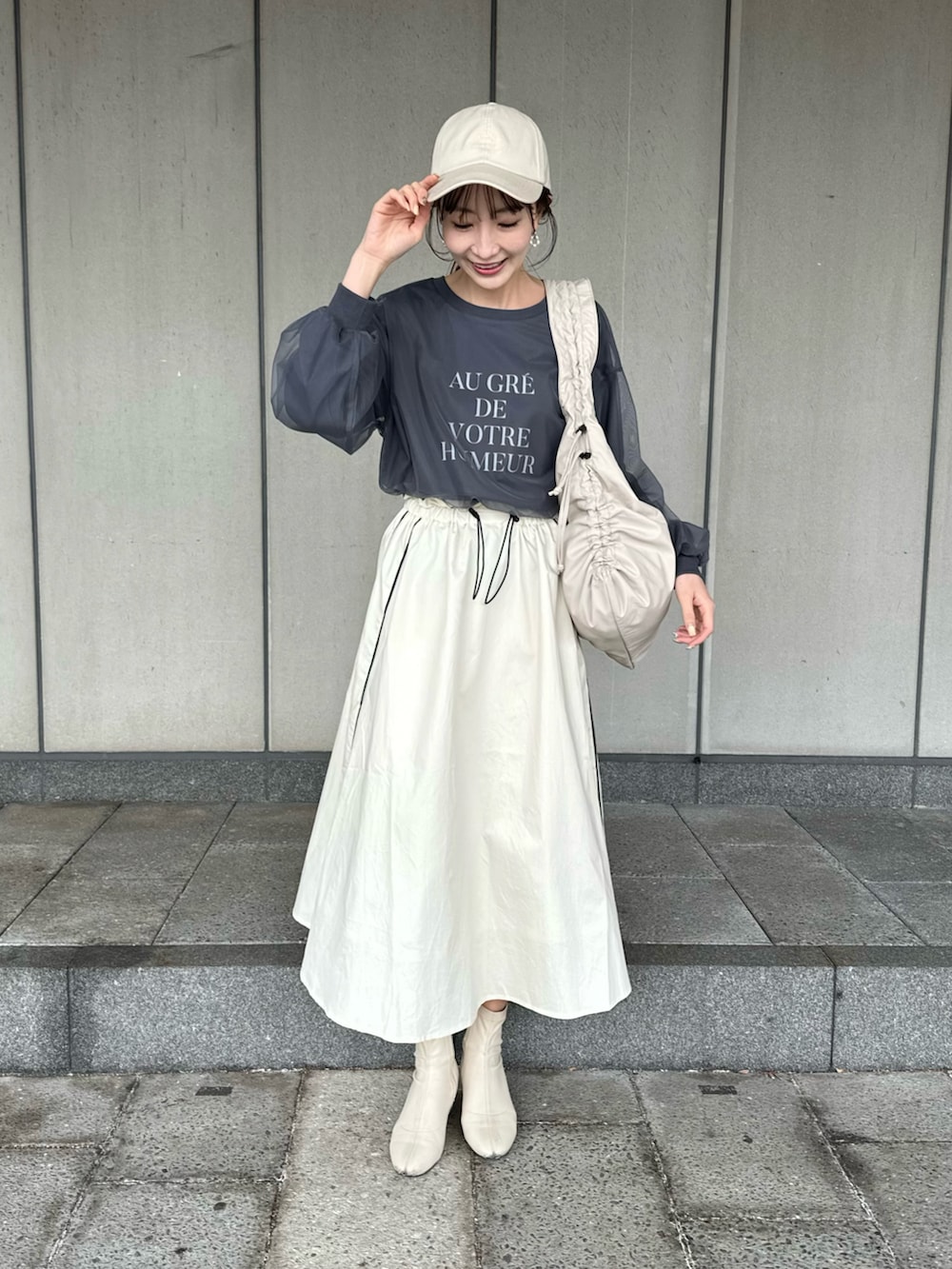 その他のトートバッグ、グレー系のスウェット、ホワイト系のスカートを着用したレディースの冬コーディネートの2枚目の写真