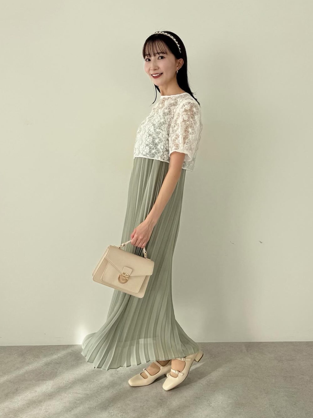 グリーン系のワンピース、ホワイト系のショルダーバッグを着用したレディースの冬コーディネートの2枚目の写真