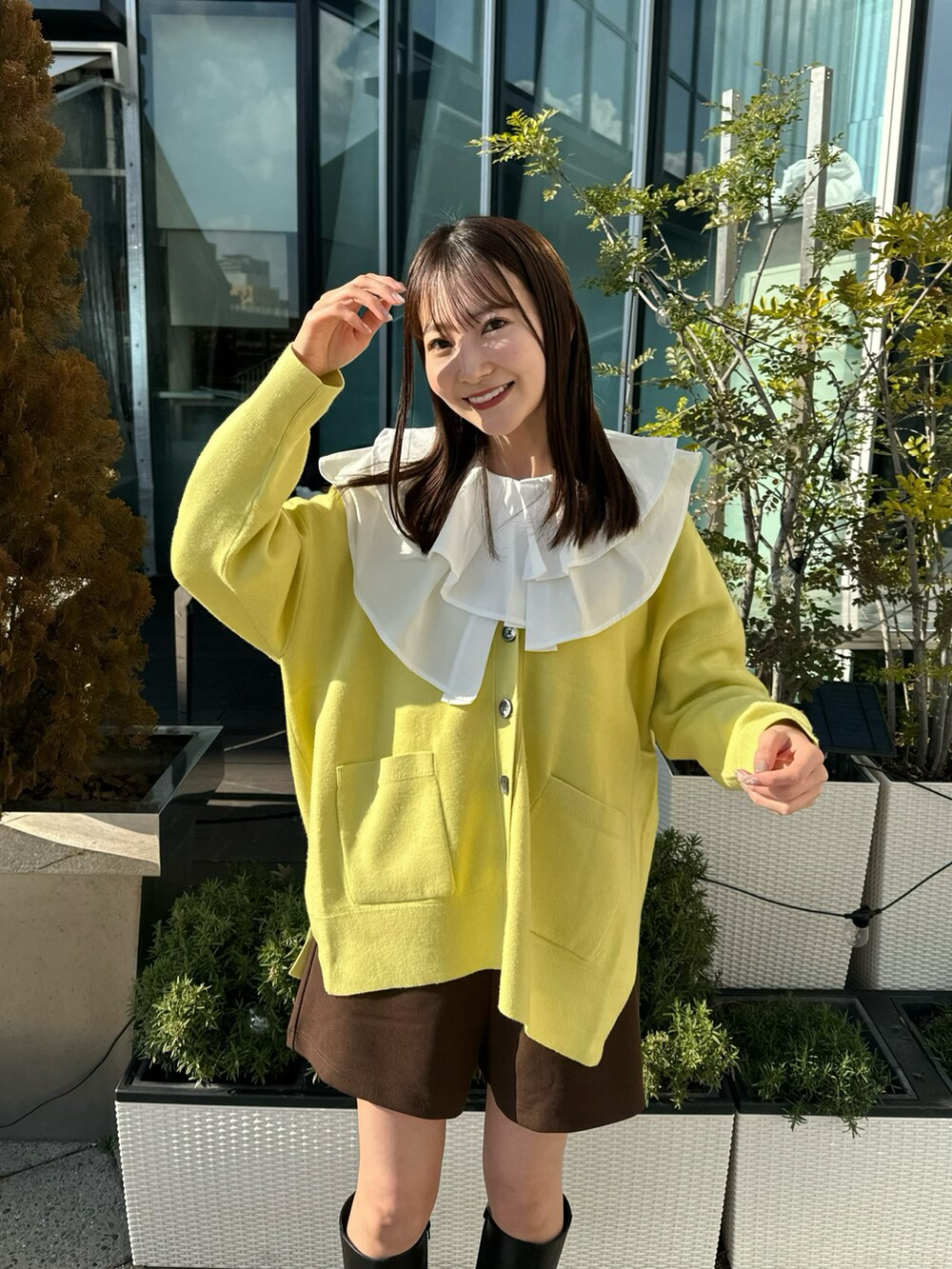 イエロー系のカーディガン/ボレロ、ホワイト系のチュニック、ブラウン系のその他パンツを着用したレディースの冬コーディネートの2枚目の写真