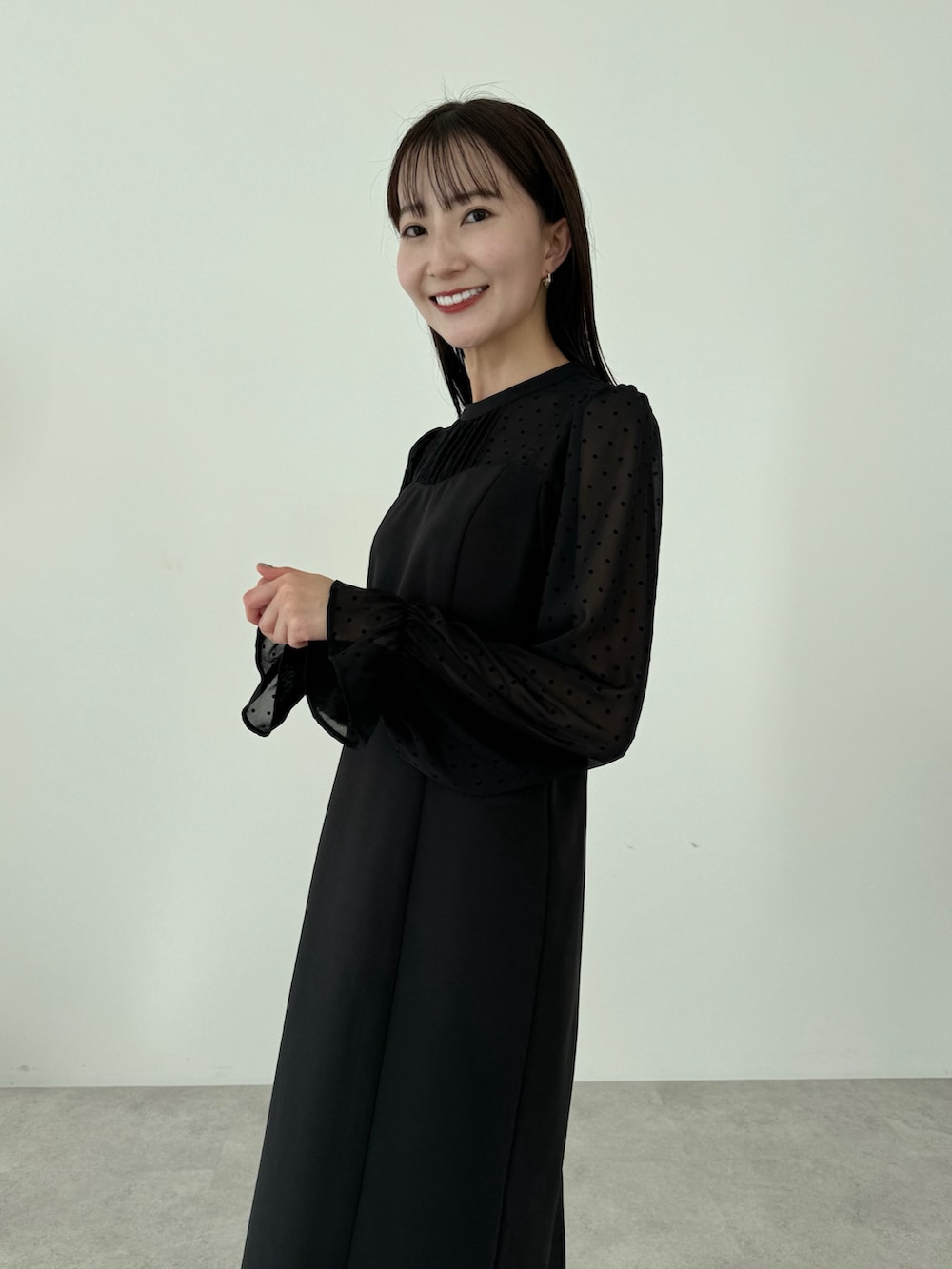 ブラック系のドレス、ブラック系のブーツを着用したレディースの春コーディネートの5枚目の写真