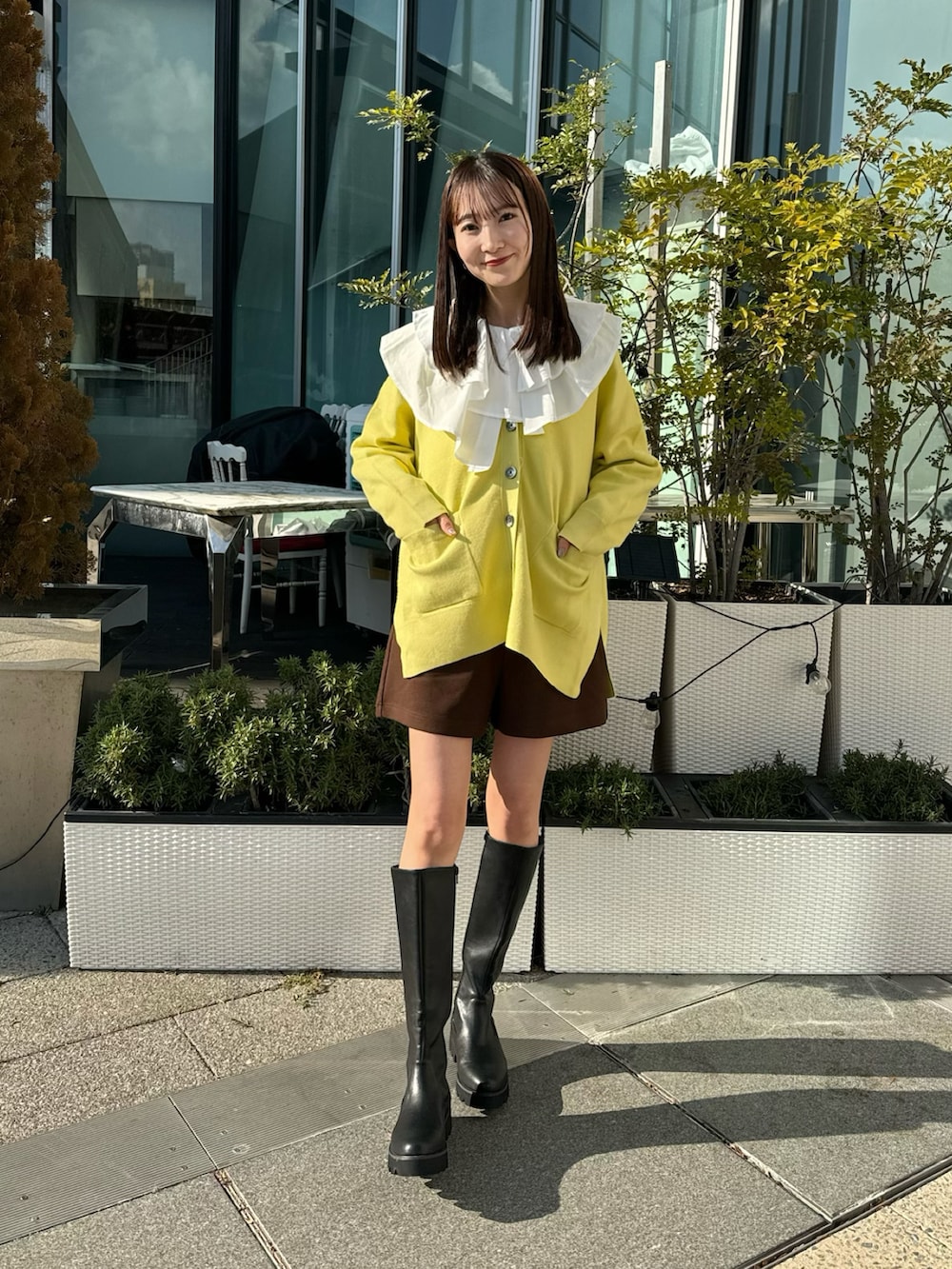 イエロー系のカーディガン/ボレロ、ホワイト系のチュニック、ブラウン系のその他パンツを着用したレディースの冬コーディネートの5枚目の写真