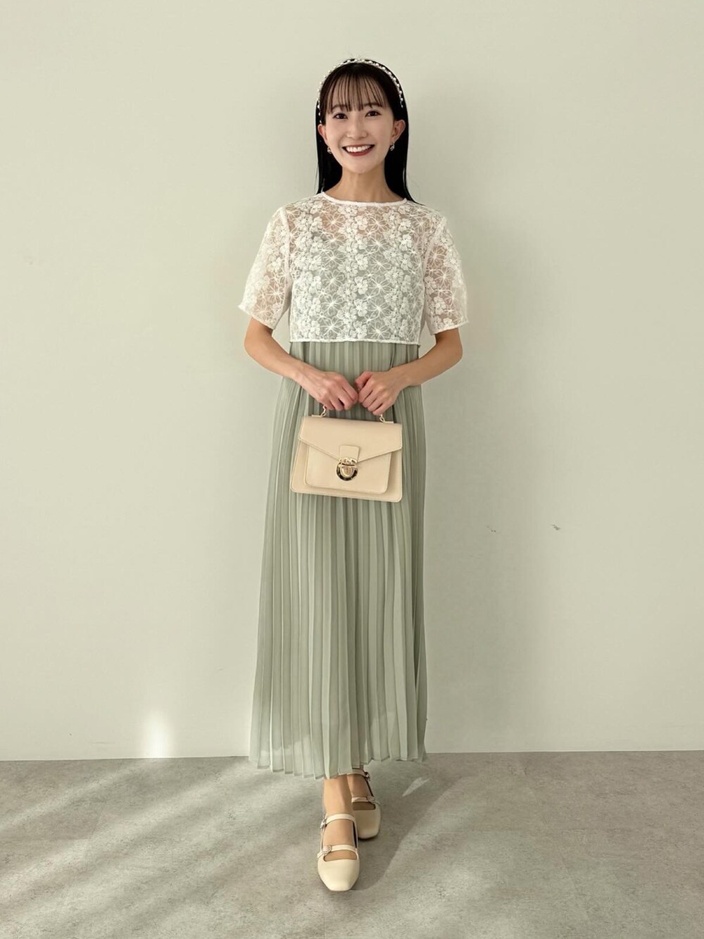 グリーン系のワンピース、ホワイト系のショルダーバッグを着用したレディースの冬コーディネートの4枚目の写真