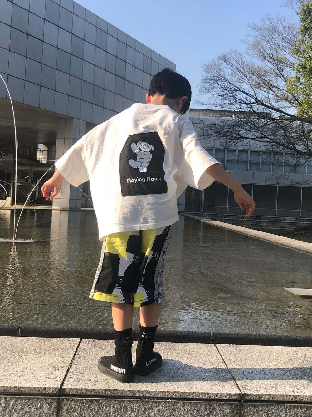 ホワイト系のTシャツ/カットソー、イエロー系のパンツ、ブラック系のシューズを着用したキッズの春コーディネートの3枚目の写真