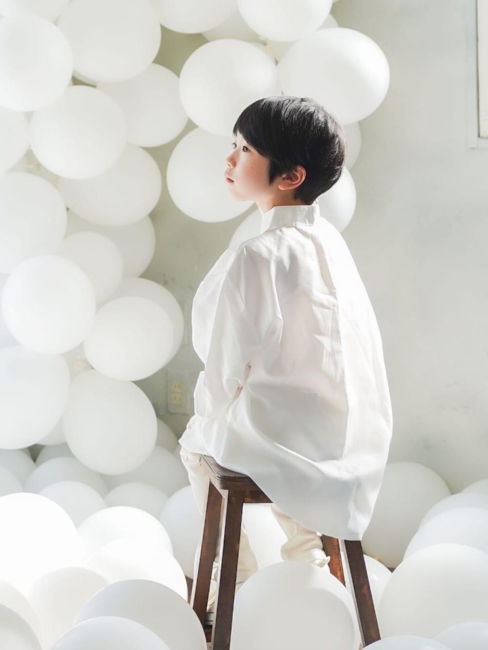 ベージュ系のパンツ、ホワイト系のスニーカーを着用したキッズの春コーディネートの2枚目の写真