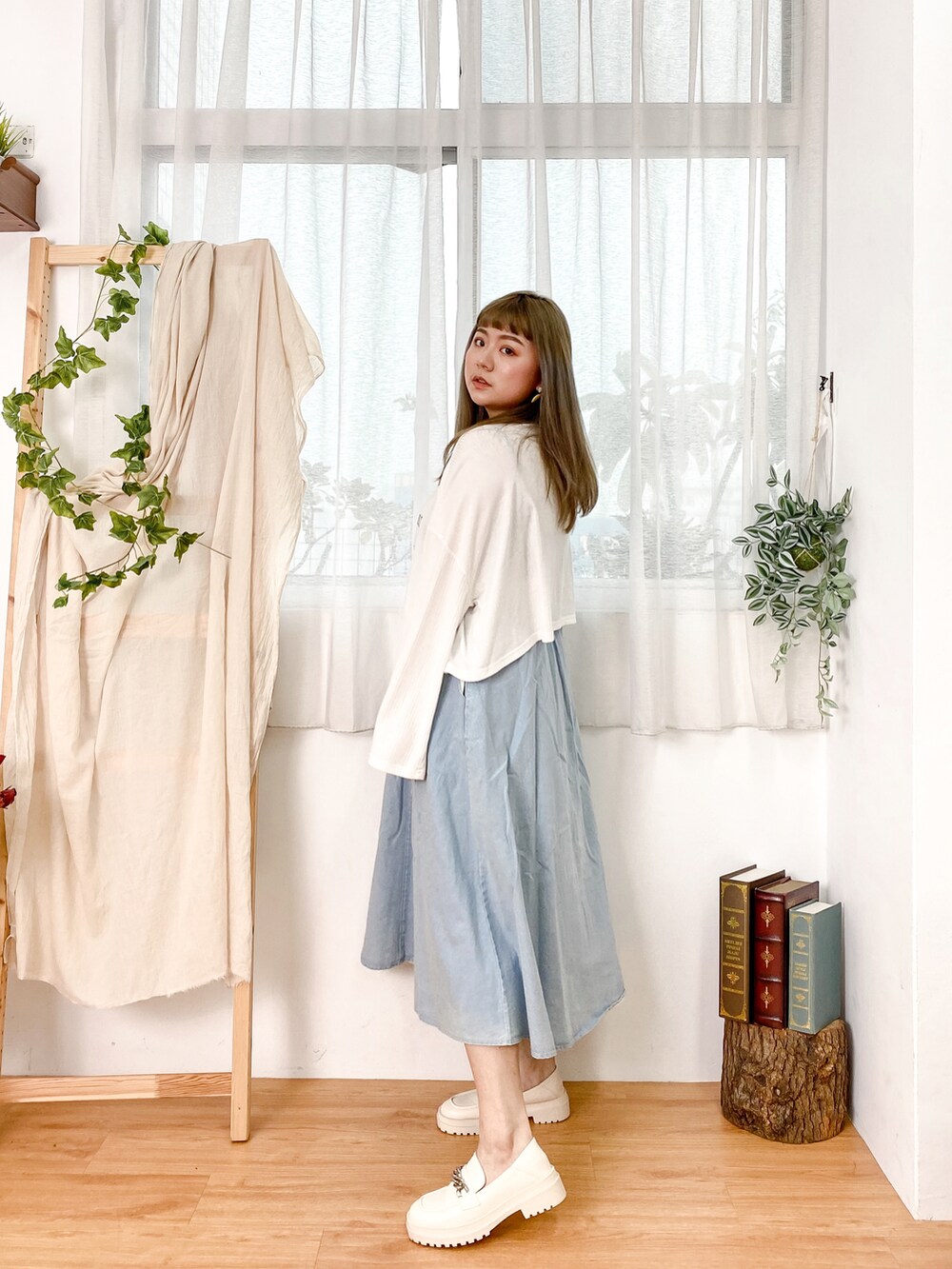 ブルー系のデニムスカート、ベージュ系のシューズ、ホワイト系のトップスを着用したレディースの冬コーディネートの3枚目の写真