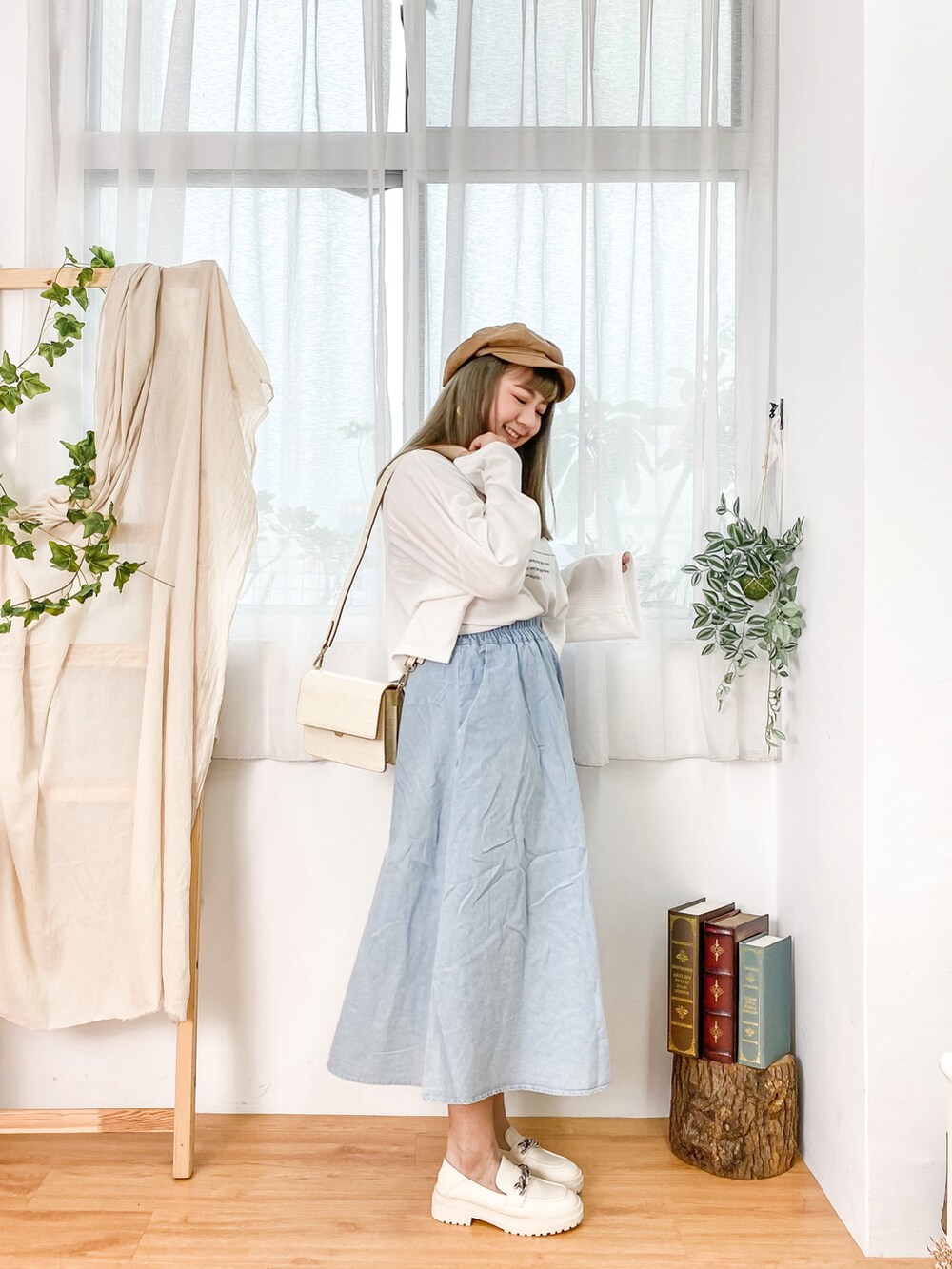 ブルー系のデニムスカート、ベージュ系のシューズ、ホワイト系のトップスを着用したレディースの冬コーディネートの2枚目の写真