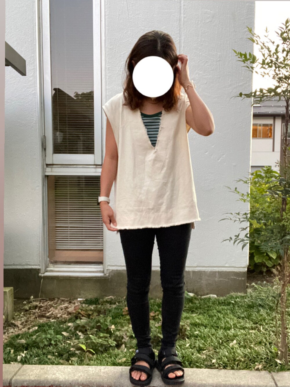 ベージュ系のベスト、グリーン系のタンクトップ、ベージュ系のキャップを着用したレディースの秋コーディネートの2枚目の写真