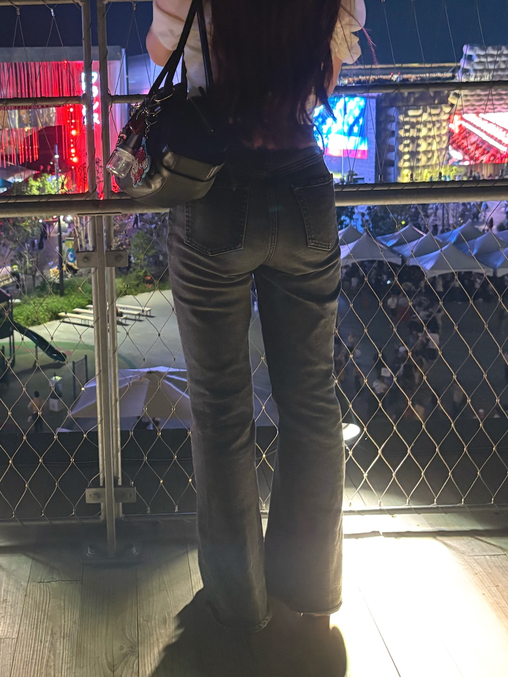 ブラック系のデニムパンツ、ブラック系のショルダーバッグ、ブラウン系のサンダルを着用したレディースの秋コーディネートの3枚目の写真