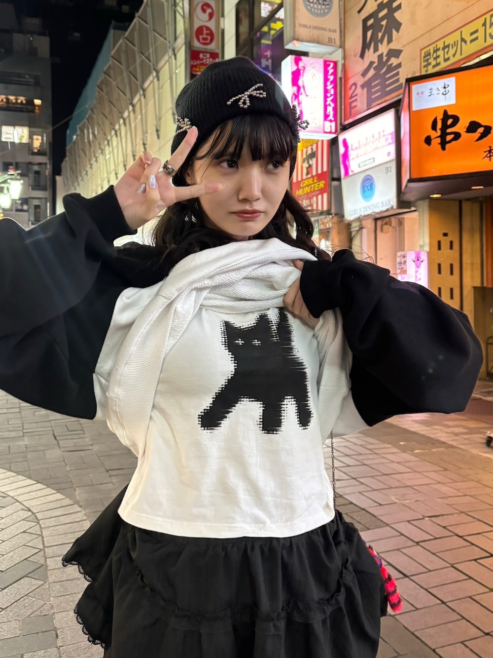 ホワイト系のパーカー、ブラック系のシューズ、ブラック系のスカートを着用したレディースの春コーディネートの2枚目の写真