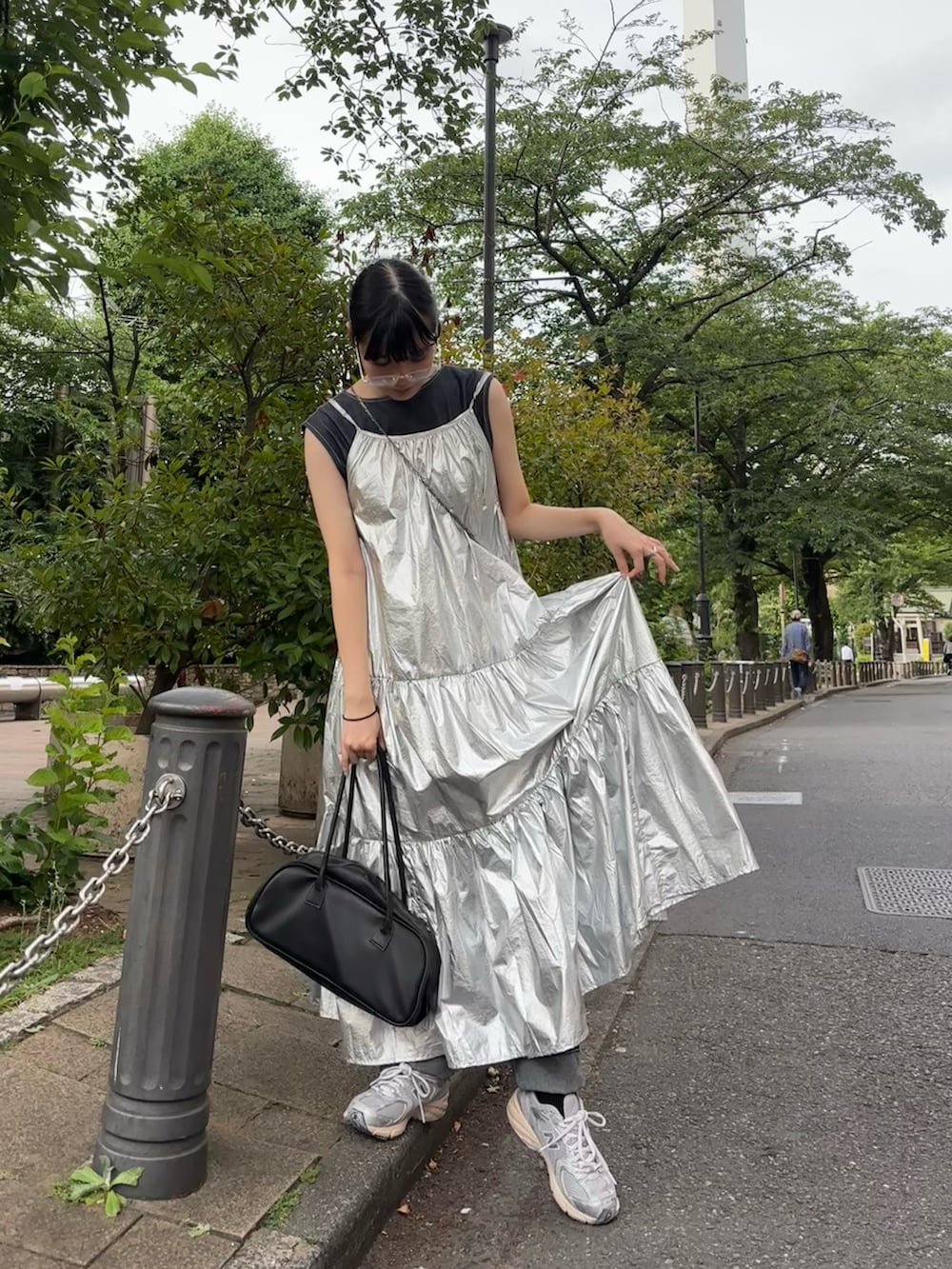 シルバー系のワンピース、ブラック系のボストンバッグ、シルバー系のスニーカーを着用したレディースの夏コーディネートの2枚目の写真