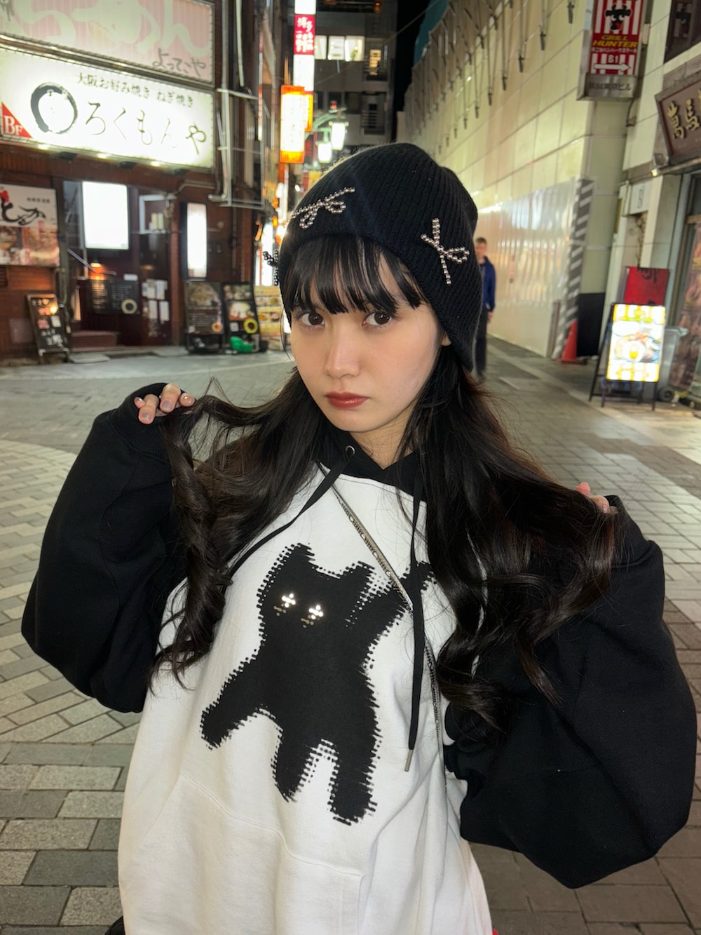 ホワイト系のパーカー、ブラック系のシューズ、ブラック系のスカートを着用したレディースの春コーディネートの3枚目の写真