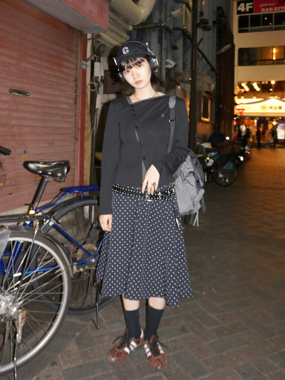 ブラック系のバックパック/リュック、ブラック系のトップス、ブラック系のキャップを着用したレディースの春コーディネートの2枚目の写真