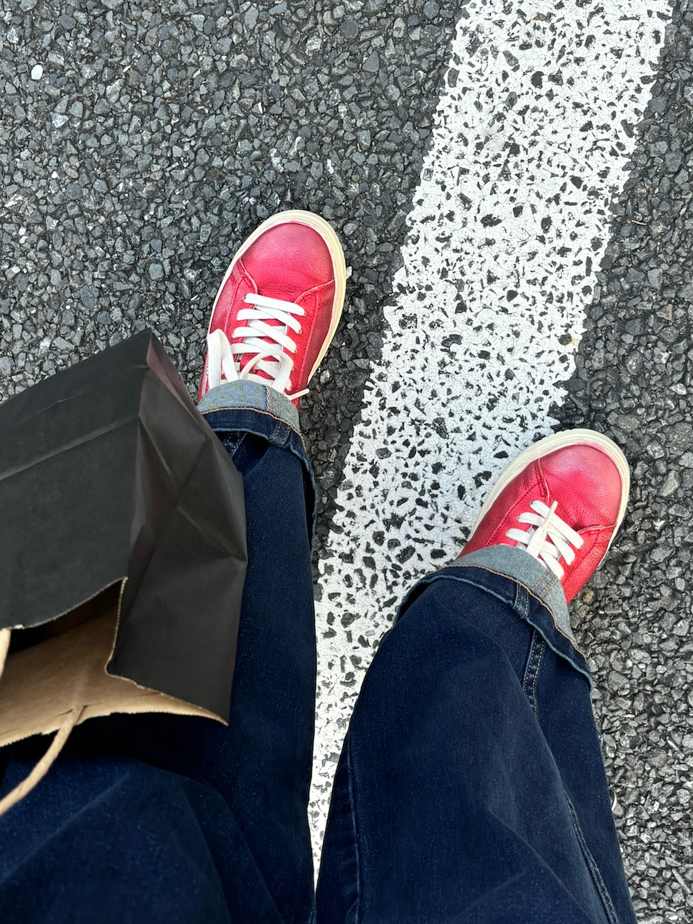 ブルー系のデニムパンツ、ブルー系のデニムジャケット、レッド系のカーディガン/ボレロを着用したレディースの秋コーディネートの2枚目の写真