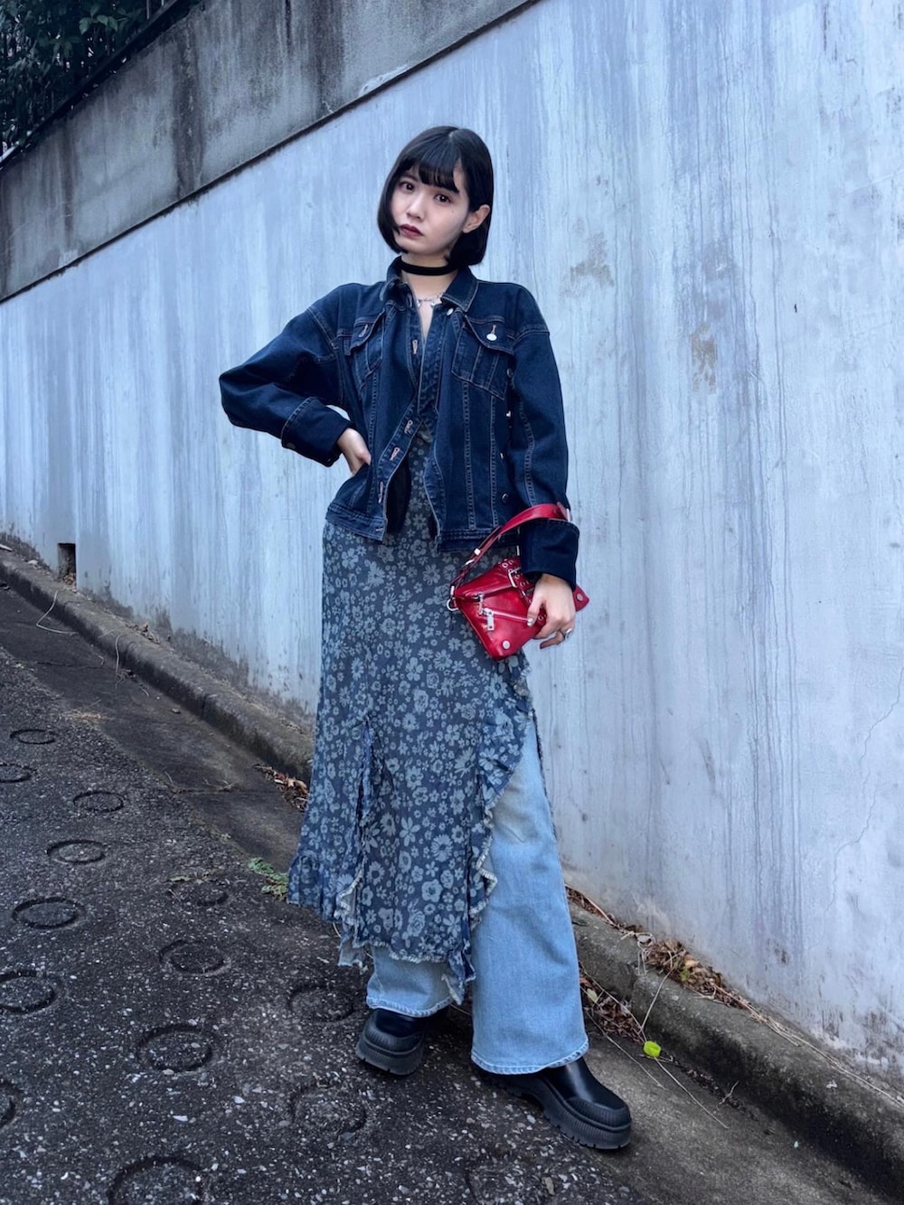 ブルー系のデニムパンツ、ブルー系のワンピース、レッド系のショルダーバッグを着用したレディースの冬コーディネートの2枚目の写真