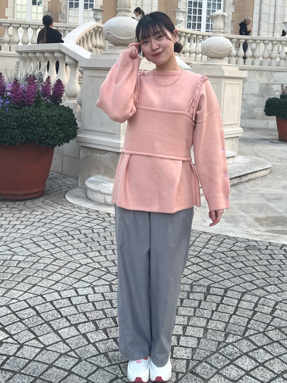 ブラウン系のトレンチコート、ピンク系のニット/セーター、グレー系のスラックスを着用したレディースの春コーディネートの2枚目の写真