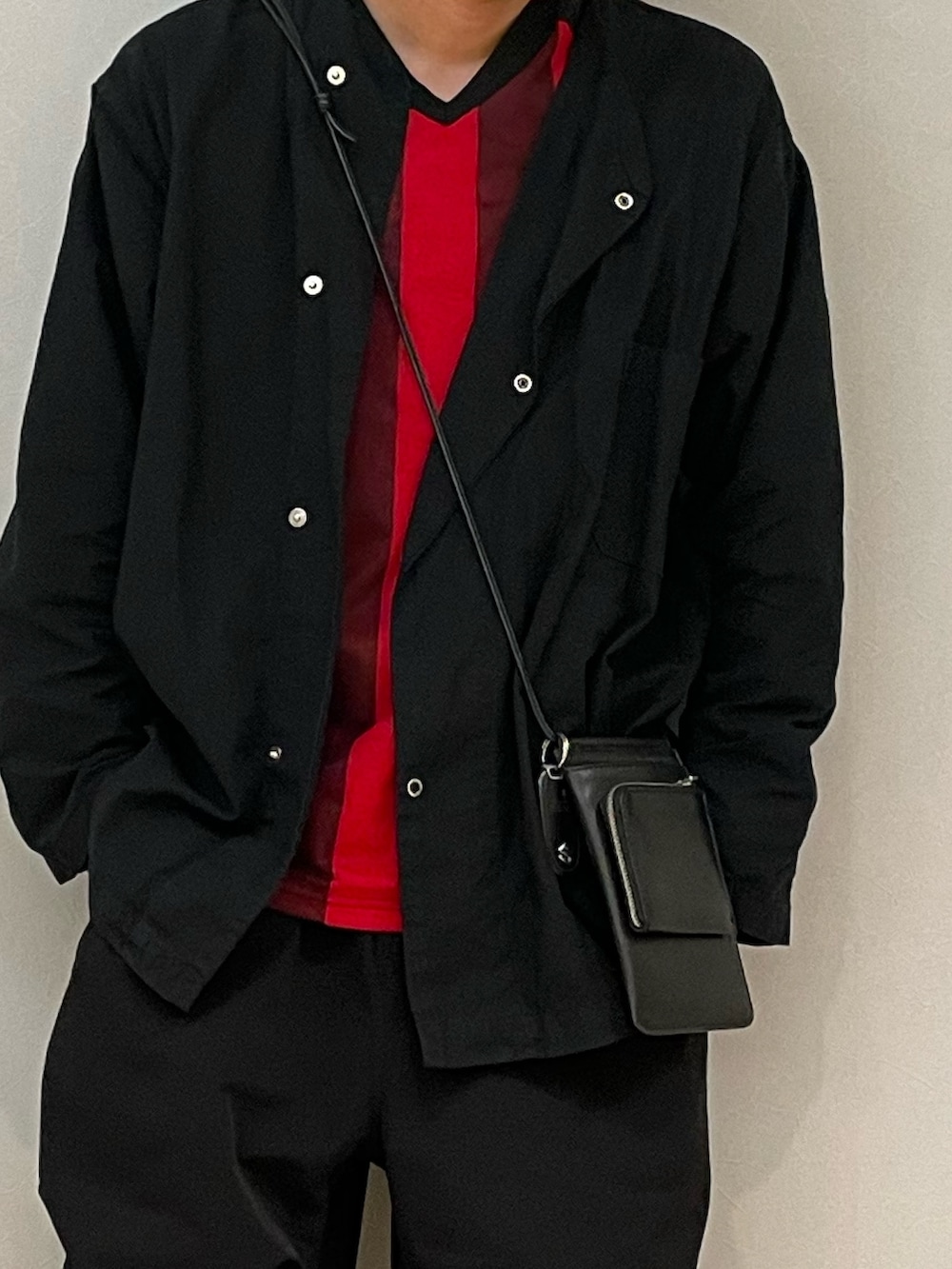 ブラック系のショルダーバッグ、ブラック系のスニーカー、グレー系のスニーカーを着用したメンズの秋コーディネートの3枚目の写真