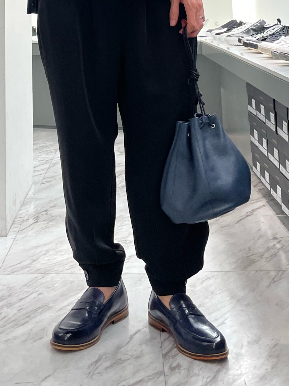 ブルー系のショルダーバッグ、ブラック系のローファー、イエロー系のローファーを着用したメンズの春コーディネートの2枚目の写真