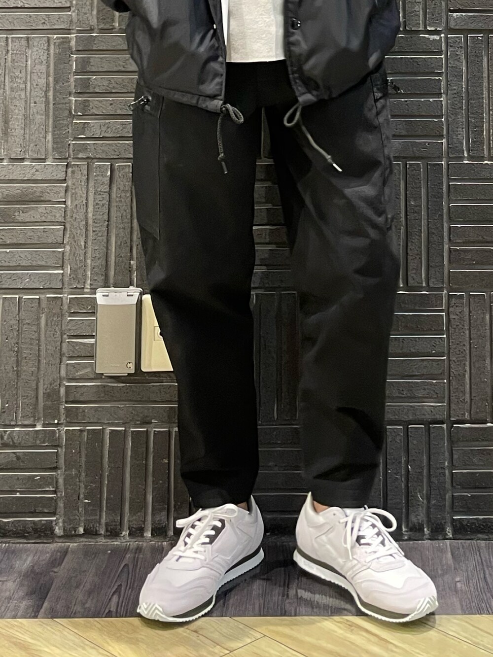 ベージュ系のニット/セーター、ホワイト系のスニーカーを着用したメンズの春コーディネートの2枚目の写真